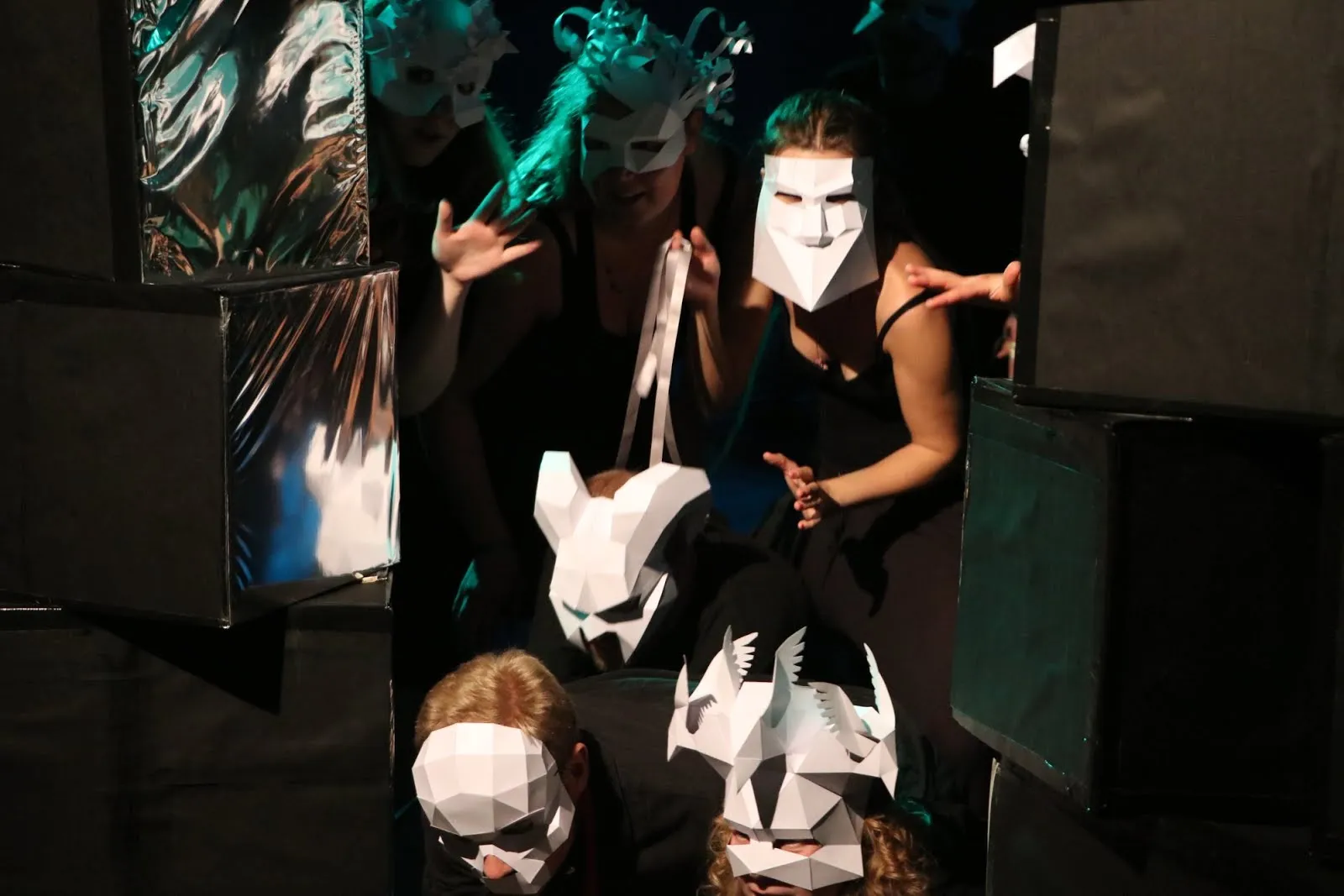 Figures with angular white masks and silvery blocks